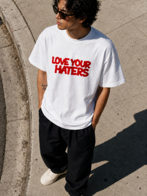 Male model wearing the Love Your Haters Red T-Shirt front view featuring oversized fit and heavyweight cotton construction